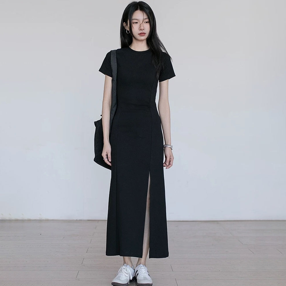Model wearing a black short-sleeve dress with a side slit